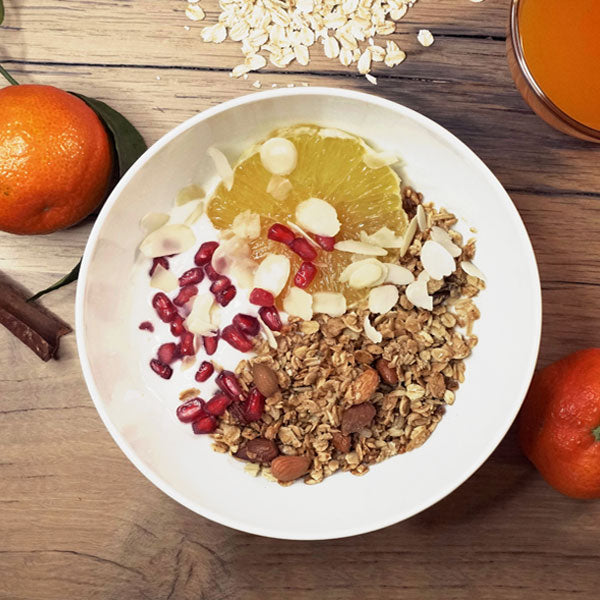 Bol de granolas à la fleur d'oranger amandes cannelle bio avec de la grenade et des filet d'amandes